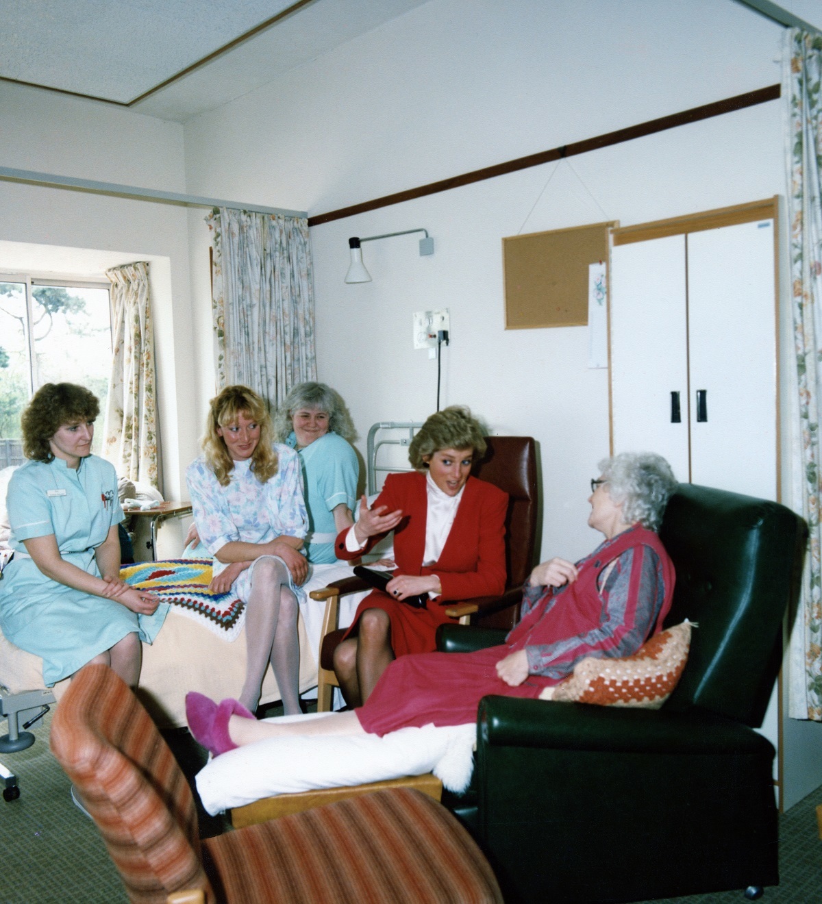 Kind words - a patient and their relative and hospice nurses listen to their special visitor