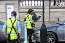 A parking warden tickets a parked car on Madeira Drive, Brighton. .PCN.Picture Allan Hutchings.
