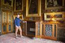 Undated handout photo issued by the National Trust of a staff member inspecting a mahogany and pietra dura mounted breakfront radiator cabinet in the Spanish Room, at Kingston Lacy, Dorset. One of the most opulent country houses in England has replaced
